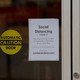 A sign about social distancing is seen at the entrance of The Container Store near Perimeter Mall on March 20, 2020 in Atlanta, Georgia. The stores are limiting the number of people allowed inside to help prevent the spread of coronavirus.